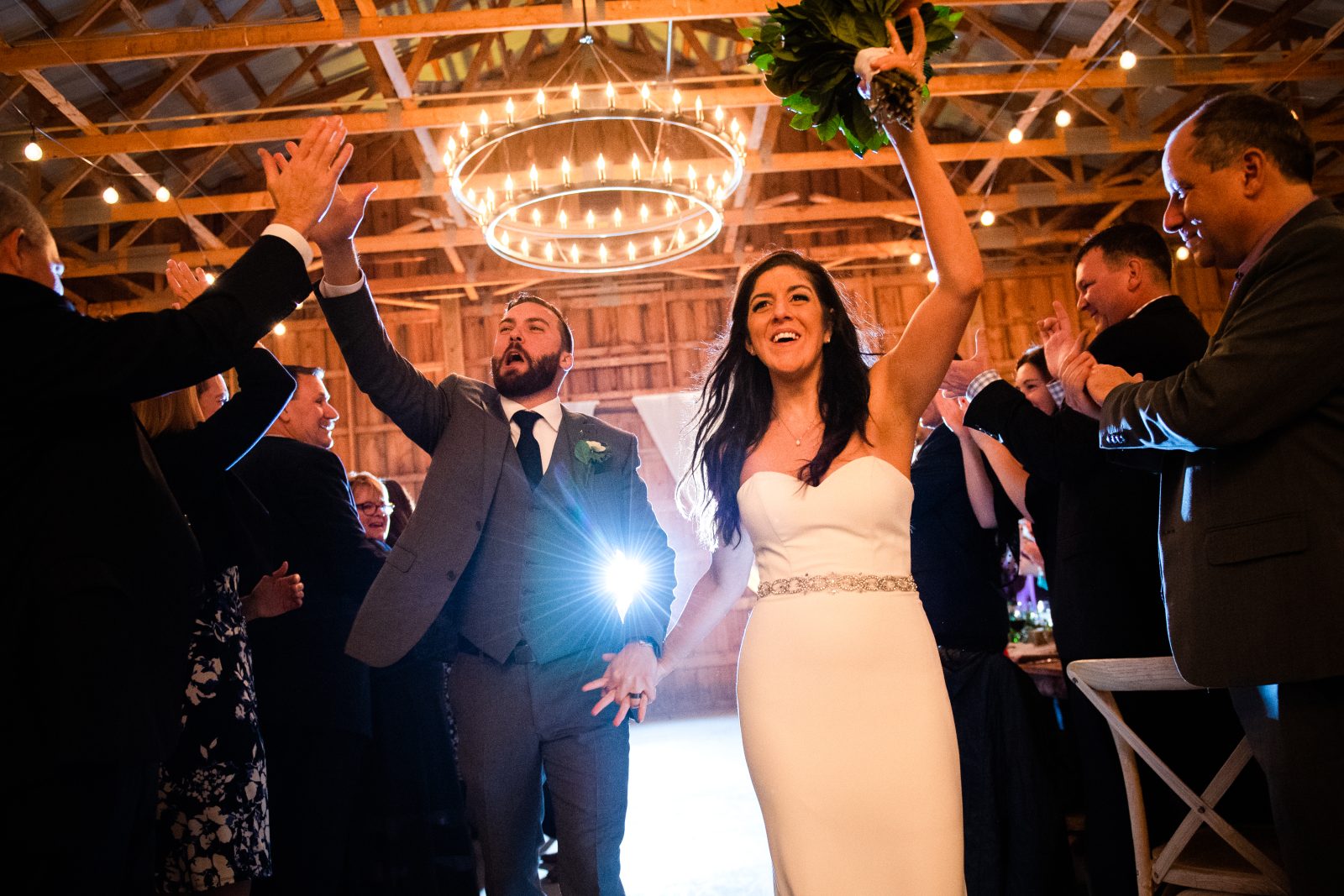Bride and groom giving high-5’s while entering their wedding reception